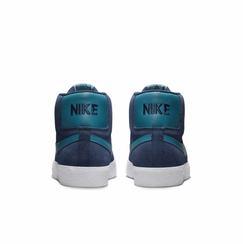 A pair of NIKE SB BLAZER MID MIDNIGHT NAVY / NOISE AQUA sneakers with white soles.