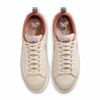 A pair of white Nike SB x Doyenne Blazer Low QS Coconut Milk / Rattan-Limestone sneakers on a white background.