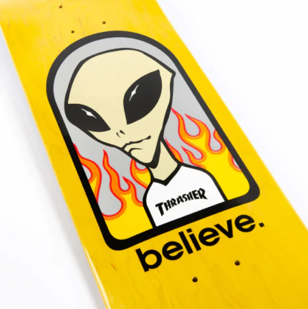A yellow ALIEN WORKSHOP skateboard with a picture of an alien on it.