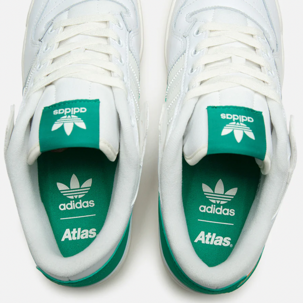 A pair of white and green ADIDAS X ATLAS FORUM 84 LOW ADV sneakers.