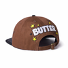 A Butter Goods brown hat with the word butter on it.