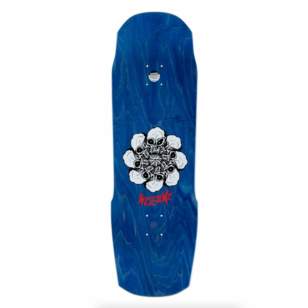 A blue WELCOME CRAZY TONY ON TOTEM skateboard with a flower on it.