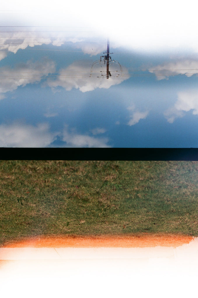 Chris Cryer is flying a Bluetile Skateboards Split Screen by Chris Cryer kite in a field, captured beautifully on a split screen photo print.