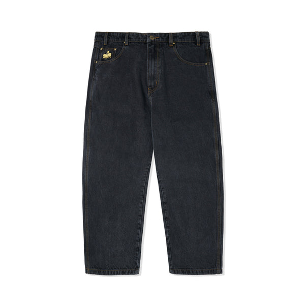 A pair of Butter Goods TIMBO DENIM PANT WASHED BLACK jeans with a gold embroidered patch.