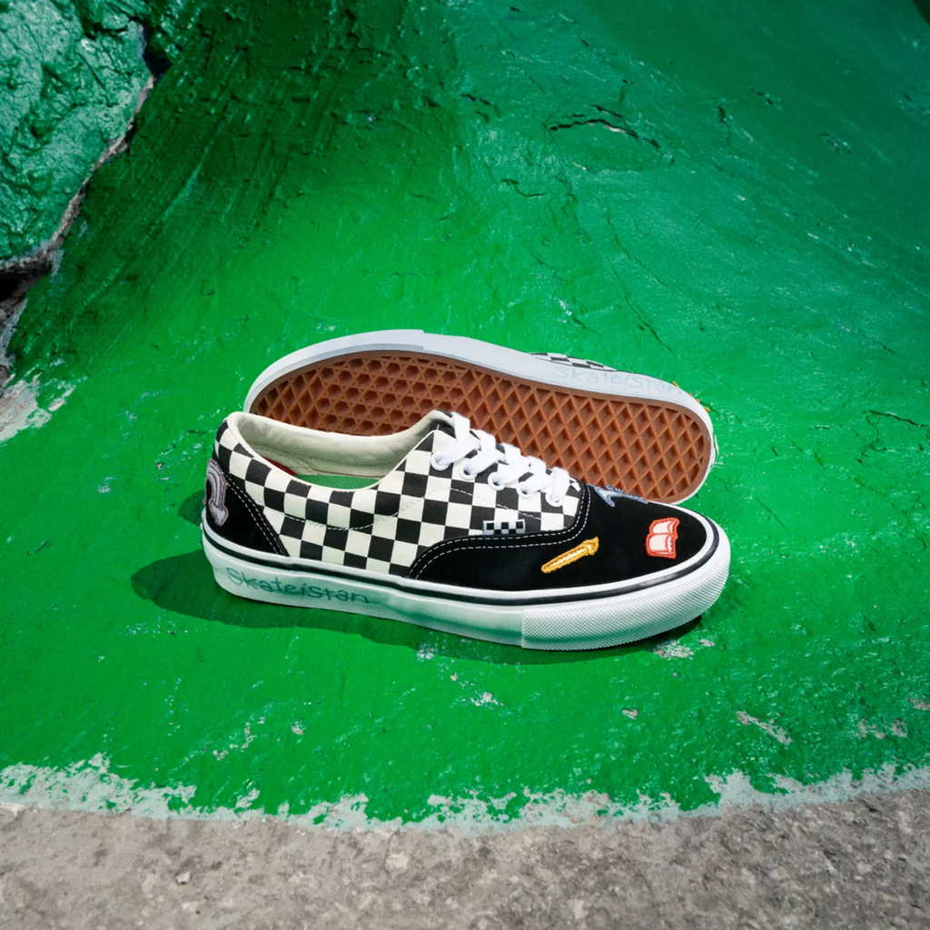 a checkered shoe with black paneling and small colorful patches on a green background