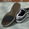 A pair of grey and white VANS SKATE WAYVEE sneakers on concrete.