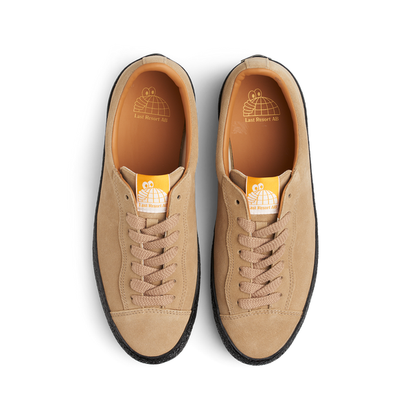 A pair of tan LAST RESORT AB VM002 SUEDE LO SAND/BLACK sneakers with orange laces.