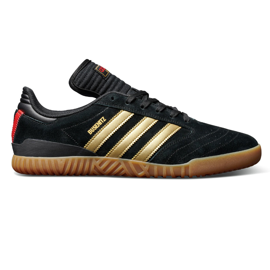 An indoor super ADIDAS BUSENITZ soccer shoe in black and gold.