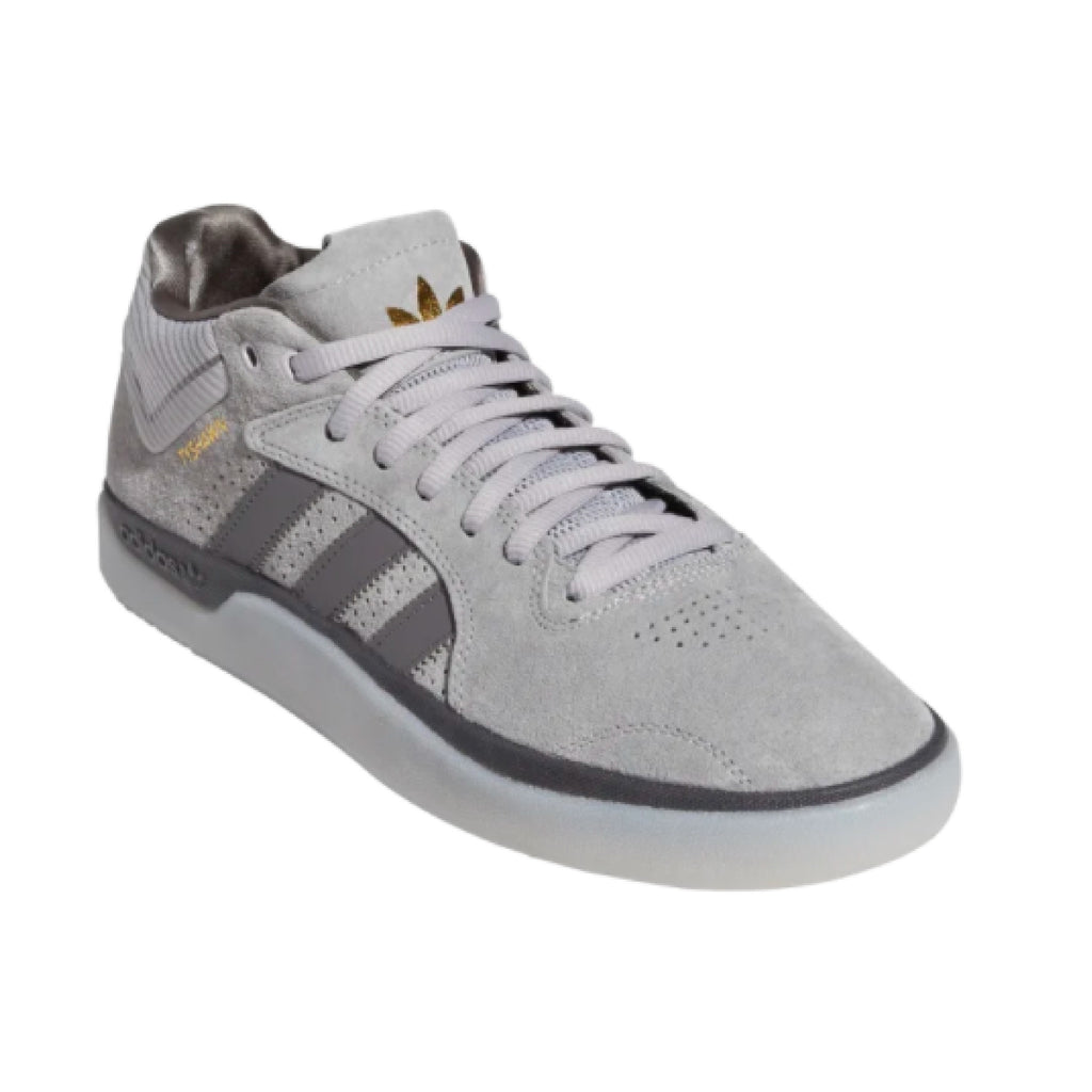 A pair of grey and gold ADIDAS TYSHAWN LIGHT GRANITE / GRANITE sneakers with a touch of light granite.