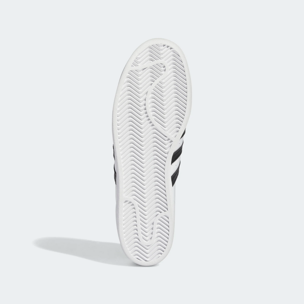 An Adidas Superstar ADV Flat White/Core Black tennis shoe on a white background.