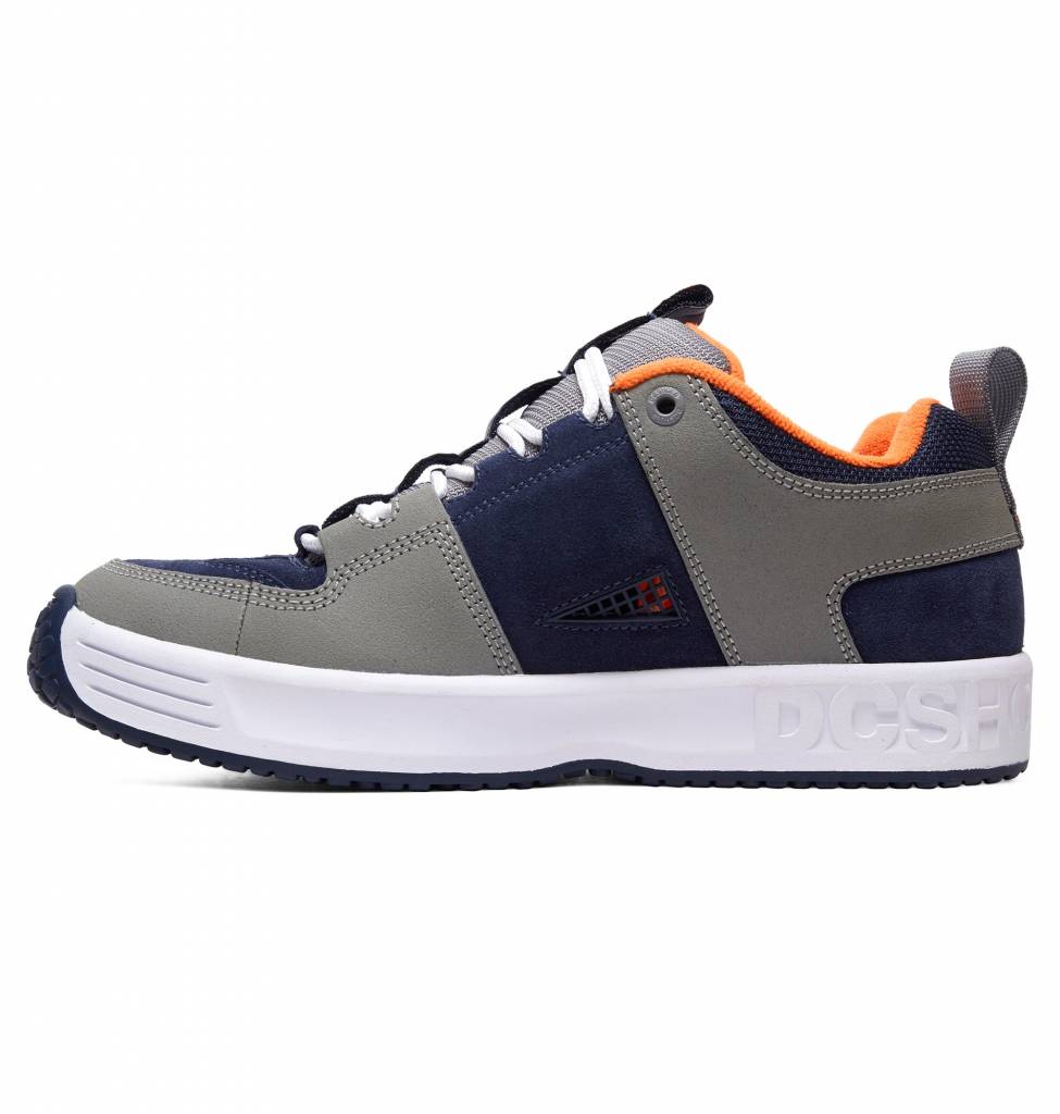 A pair of men's grey and orange DC HERITAGE LYNX OG sneakers from the DC heritage line.