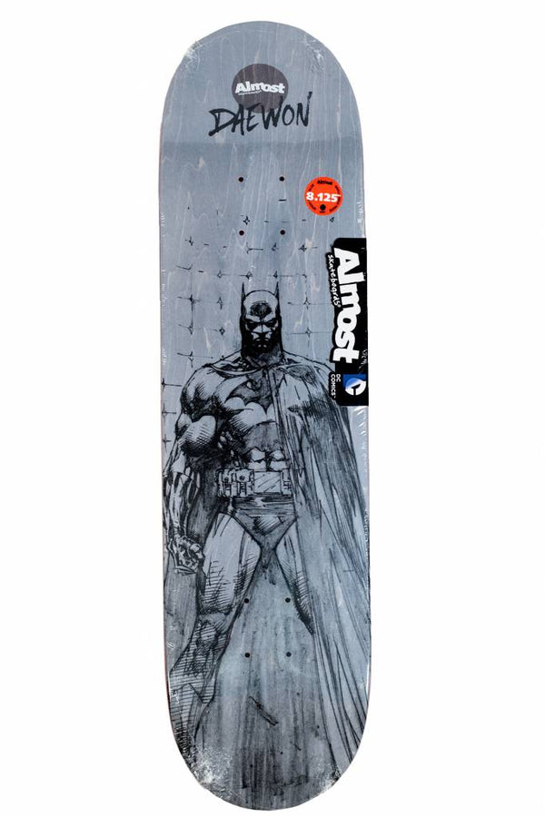 The ALMOST DAEWON BATMAN SKETCH 8.125 skateboard deck features a black and white Batman sketch, "ALMOST" and "DAEWON" branding, plus a red size sticker.