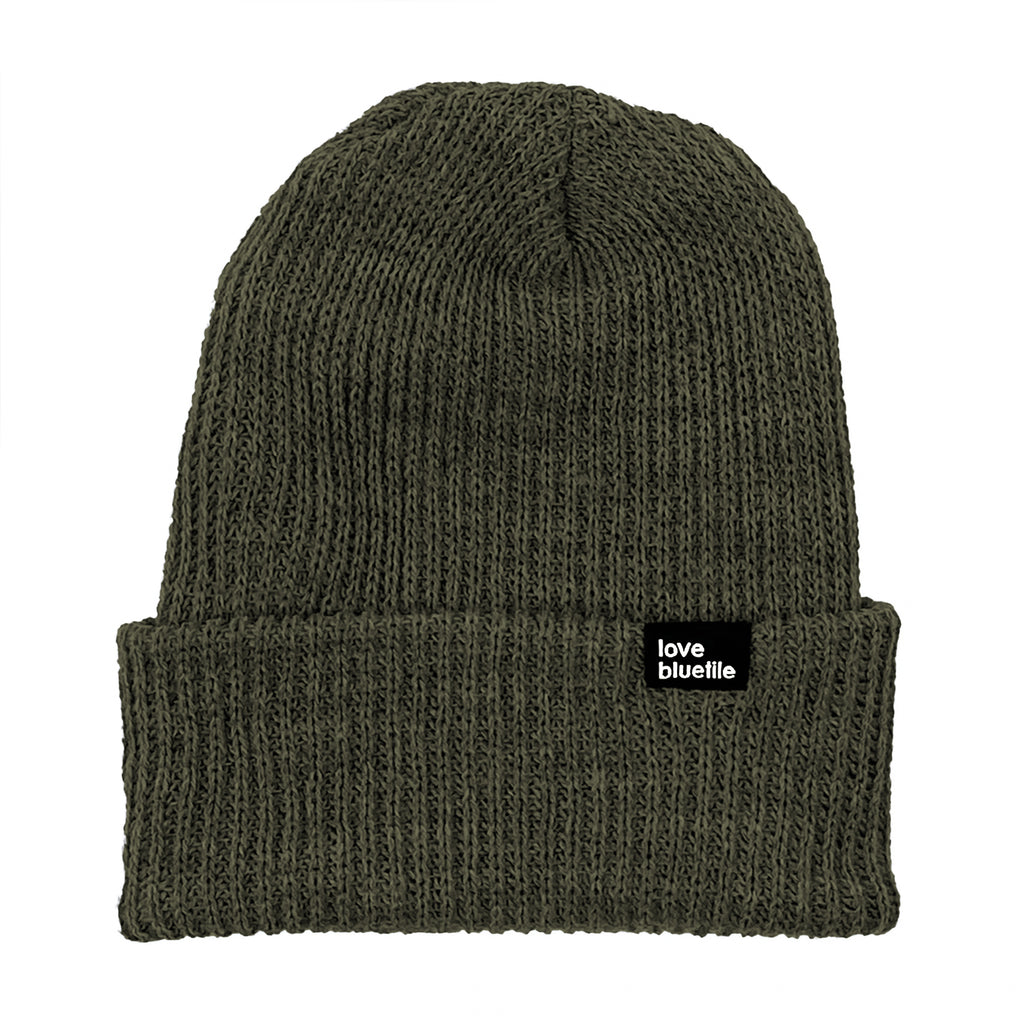A Bluetile Skateboards olive knit beanie with a black label on it.