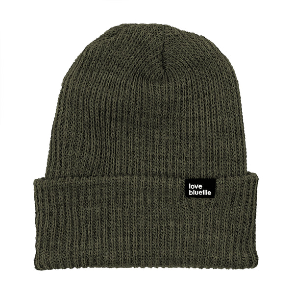 A BLUETILE LOVE ALWAYS KNIT BEANIE OLIVE with a black label on it.