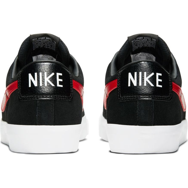 Rear view of a pair of NIKE SB BLAZER LOW GT BLACK / UNIVERSITY RED sneakers with white soles. The shoes feature a University Red stripe on the side, and the brand name "nike" is prominently displayed in white on the back. Available now at Bluetile Skateboards.