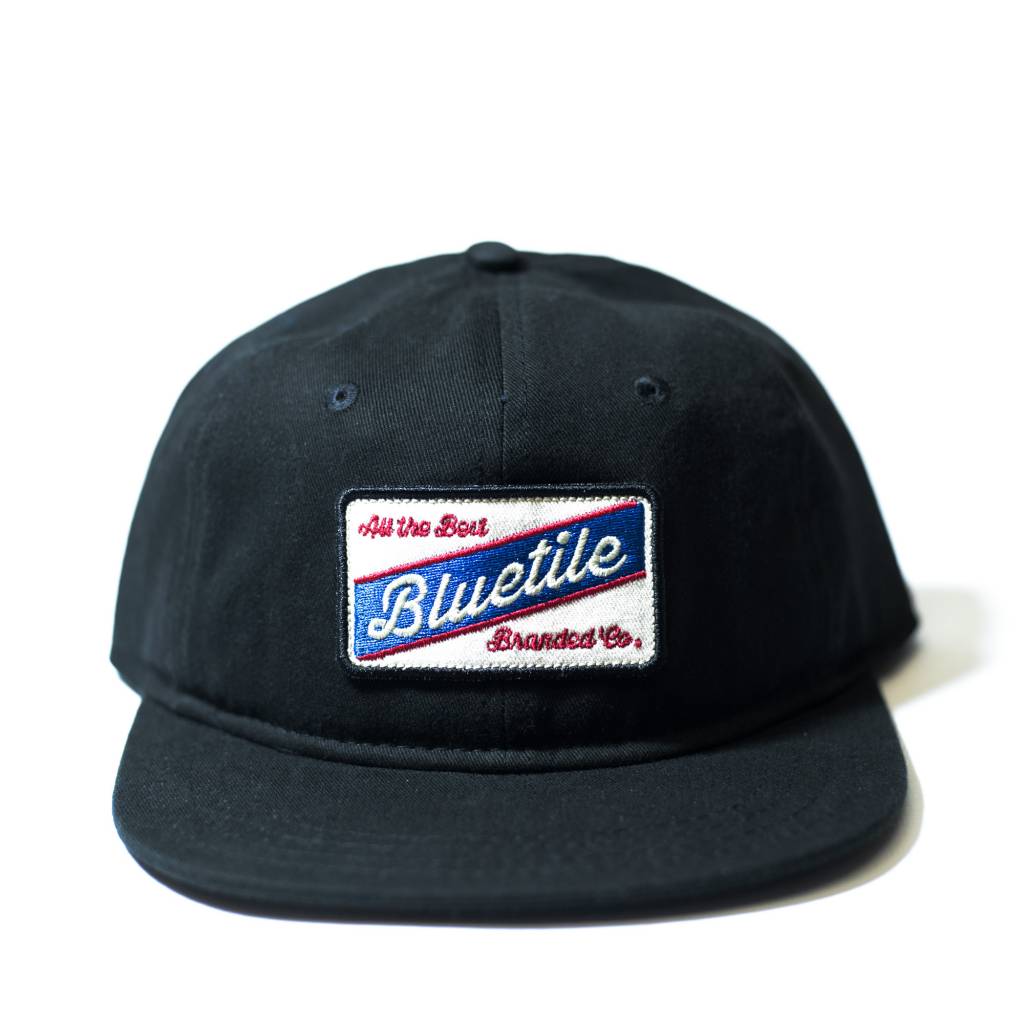 A black hat with a blue and white BLUETILE "ALL THE BEST" COLOR PATCH BLACK on it from Bluetile Skateboards.