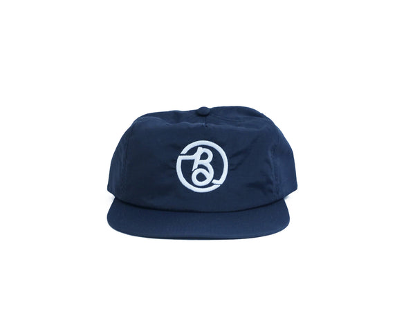A BLUETILE SUPPLY CO NYLON SURF HAT NAVY with a white logo on it, made of nylon fabric. Brand Name: Bluetile Skateboards.
