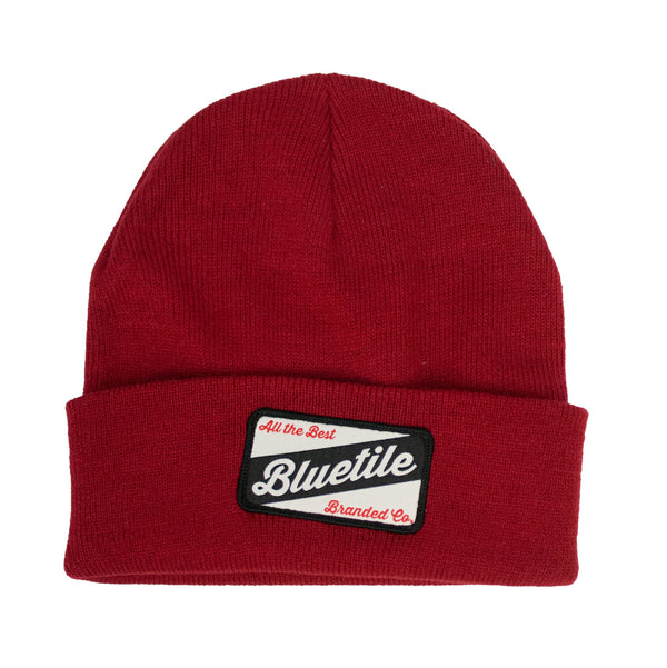 A red BLUETILE CRAFT PATCH BEANIE CARDINAL with the word blueville and a cardinal patch on it by Bluetile Skateboards.
