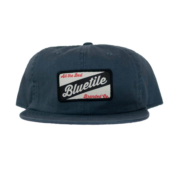 A BLUETILE CRAFT PATCH HAT PETROL BLUE with the word Bluetile Skateboards on it.