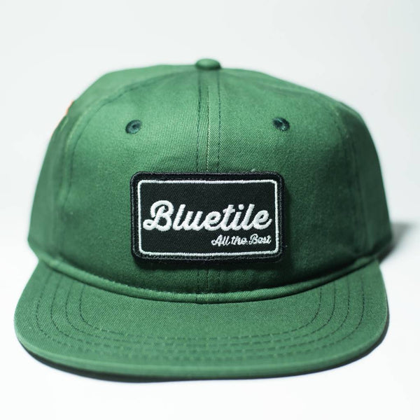 A better BLUETILE "ALL THE BEST" PATCH FOREST GREEN hat with the word Bluetile Skateboards on it.