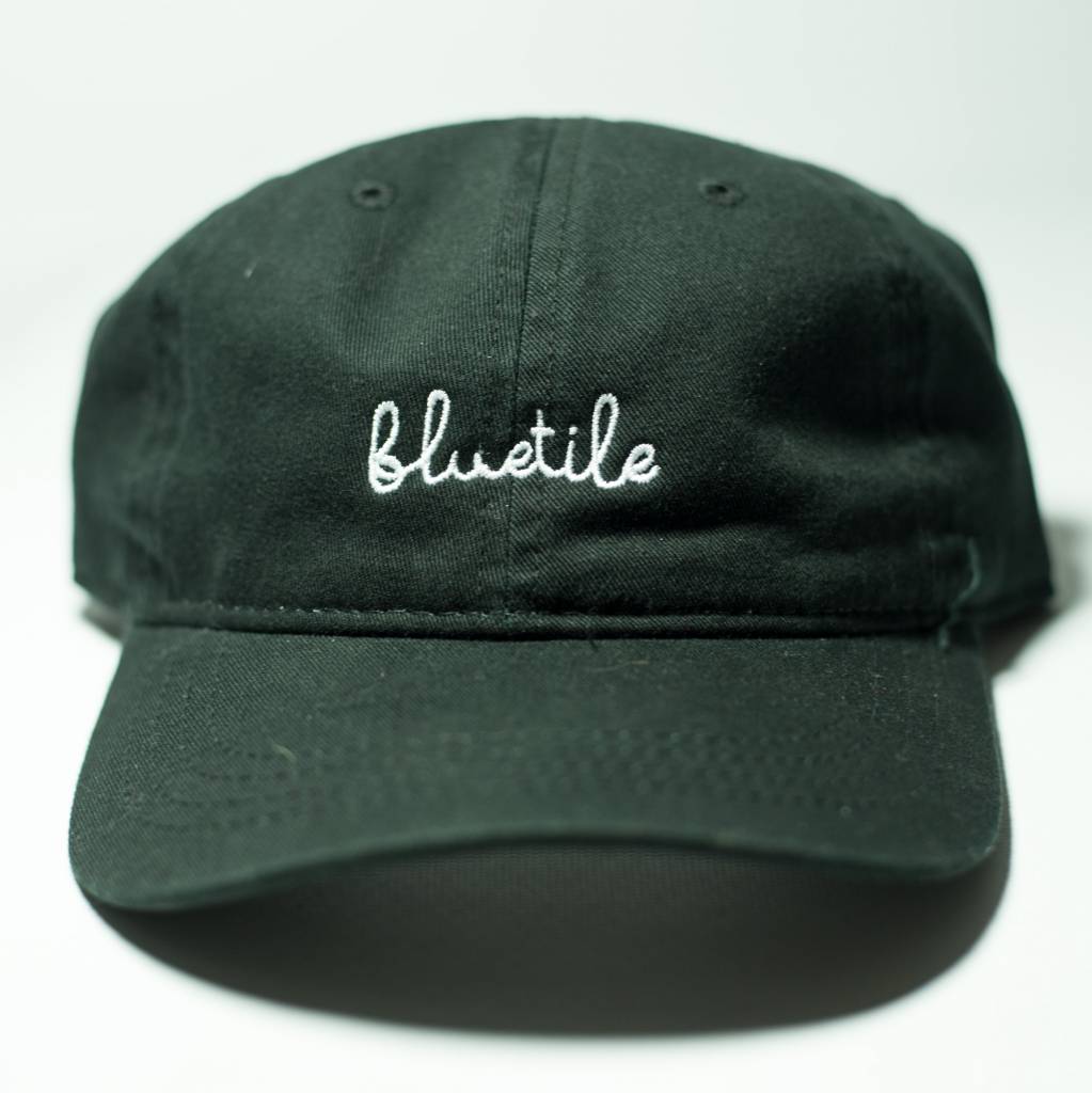 A black BLUETILE SCRIPT DAD HAT BLACK with the word 'blustle' embroidered on it.