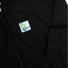 A Bluetile Sketchy Gonz zip hoodie black with a yellow sticker on it.