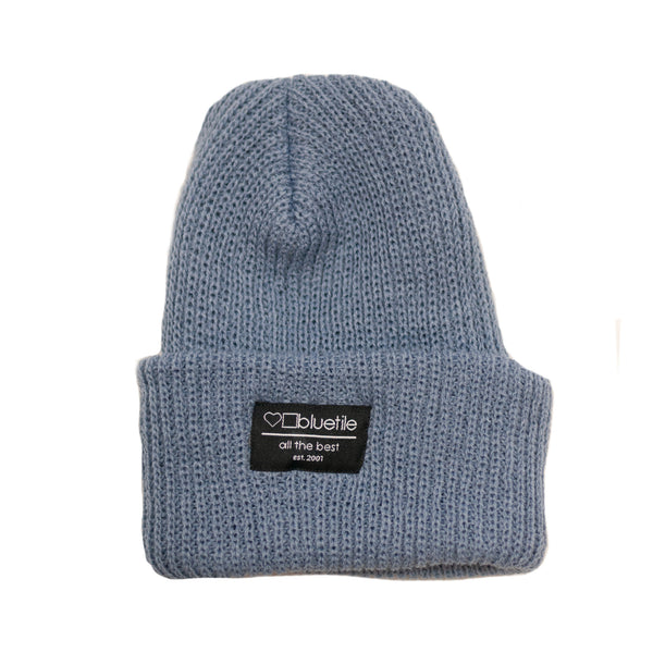 A BLUETILE SURPLUS KNIT BEANIE LIGHT DENIM with a label on it. (Brand: Bluetile Skateboards)