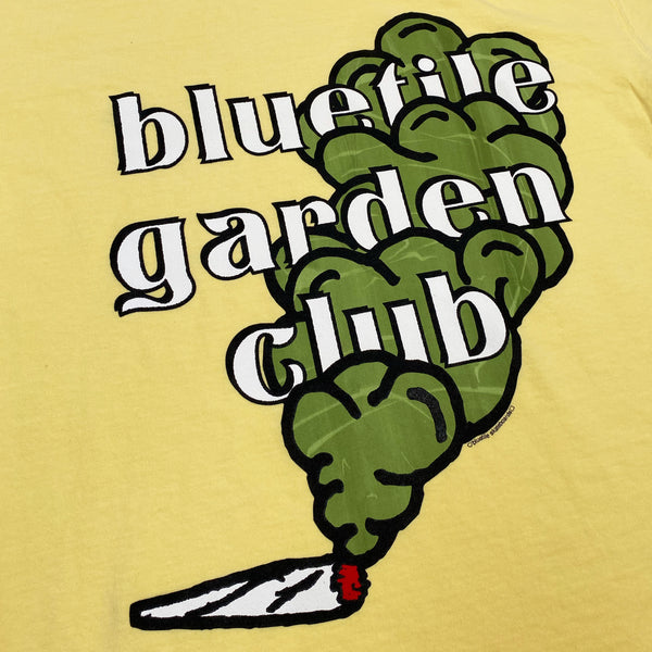 A BLUETILE GARDEN CLUB TEE BUTTER with the words BLUETITE GARDEN CLUB on it.