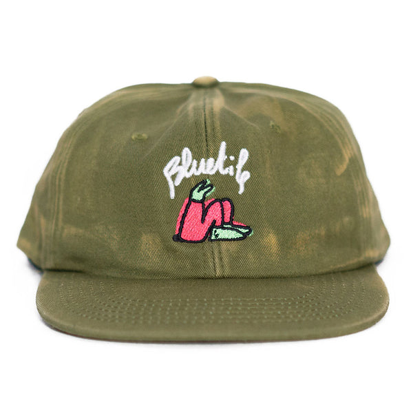 A BLUETILE X LUCAS BEAUFORT HAT FADED OLIVE, designed by Lucas Beaufort, with a pink flower on it.