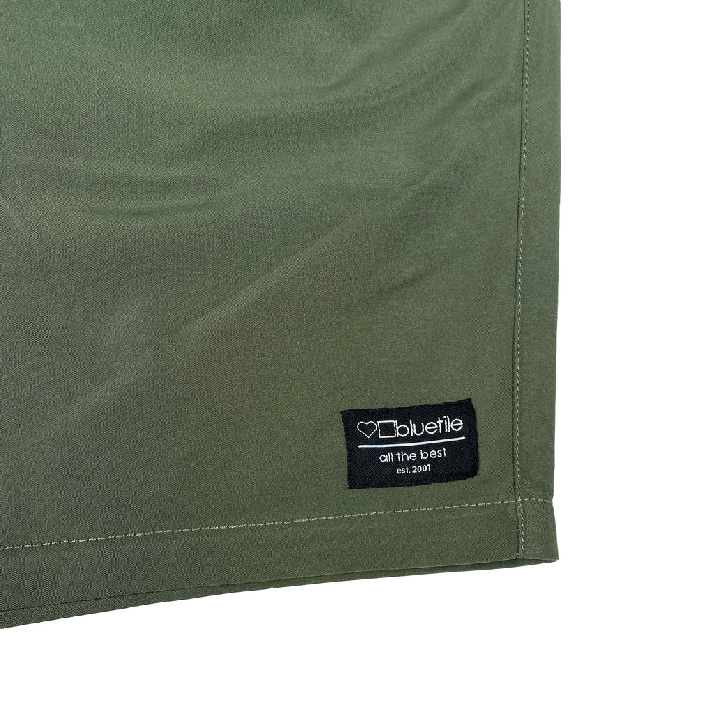 A pair of Bluetile Skateboards green shorts with a logo on the side, perfect for a workout.