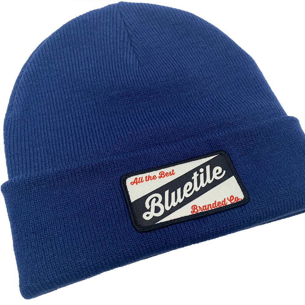 A Bluetile Craft Patch Beanie Cobalt by Bluetile Skateboards with a patch on it.