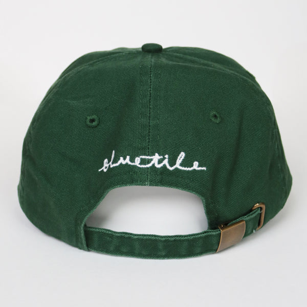 A BLUETILE X SPINA HEART & SQUARE HAT GREEN with the word schuttle written on it. Brand Name: Bluetile Skateboards