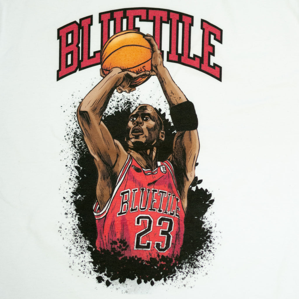 A Bluetile Skateboards white BLUETILE JUMP SHOT T-SHIRT with a basketball player executing a jump shot on it.
