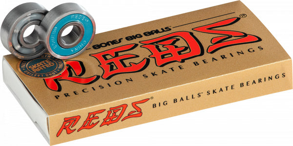 A box containing BONES REDS BIG BALLS BEARINGS 8 PACK skateboard bearings with the brand name BONES sitting on top, accompanied by a pair of skateboard wheels.