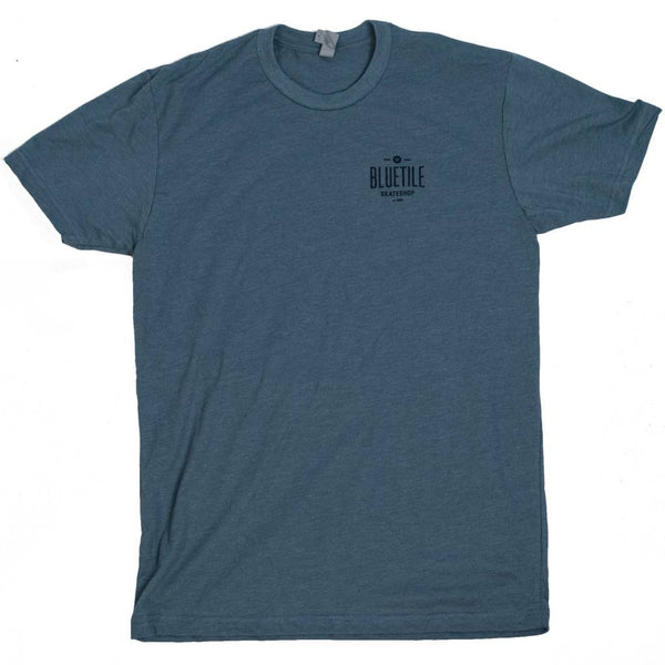 A cool BLUETILE 100% SKATEBOARDING - BLUE / BLUE shirt with a black Bluetile Skateboards logo, perfect for skateboarding.