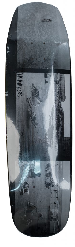 A black and white photo of a person on a Bluetile Skateboards BLUETILE NEIGHBOR BEACH SHOVELNOSE 9.0 skateboard.