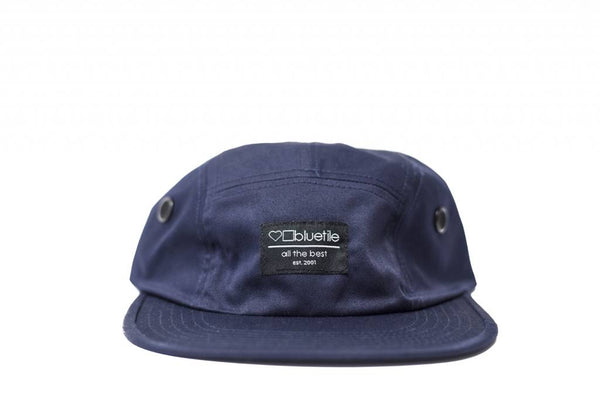 A Bluetile Skateboards BLUETILE SURPLUS 5 PANEL HAT NAVY with a Bluetile Skateboards label on the front.