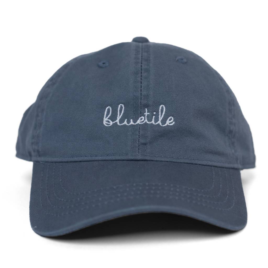 A BLUETILE SCRIPT DAD HAT SLATE BLUE with the word 'blush' embroidered in cursive.