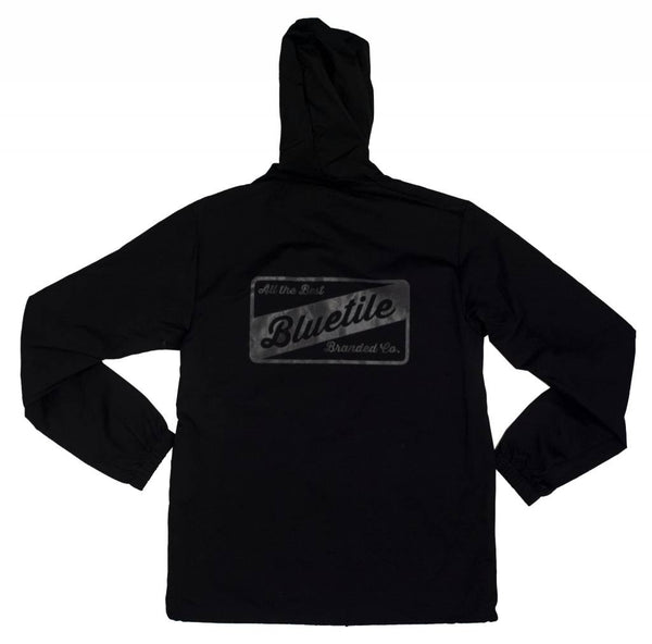 A BLUETILE ALL THE BEST COACHES JACKET BLACK / BLACK with a waterproof and reflective ink logo on it.