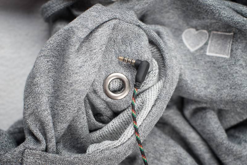 A close up of a BLUETILE LOVE BLUETILE PREMIUM HOODIE GRAY with an earphone plugged in. (Brand: Bluetile Skateboards)