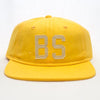 A Bluetile Skateboards "BS" yellow hat with the letter bs on it.