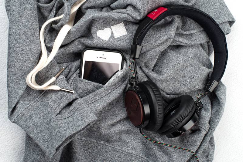 A Bluetile Skateboards BLUETILE LOVE BLUETILE PREMIUM HOODIE GRAY with headphones and a cell phone.