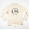 A beige BLUETILE SINCE 2001 REFLECTIVE INK COACHES JACKET with a black logo on it by Bluetile Skateboards.