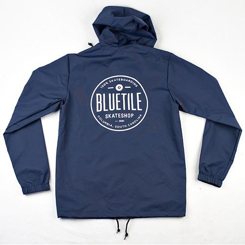 A Bluetile Skateboards BLUETILE SINCE 2001 HOODED COACHES JACKET NAVY with a white logo on it.