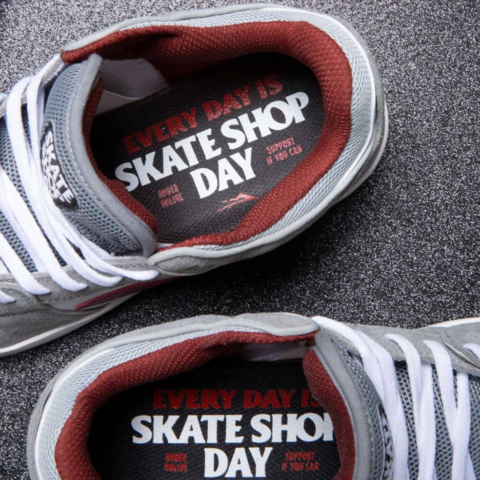 The LAKAI X SKATE SHOP DAY TELFORD LOW shoes proudly feature the words "SKATE SHOP DAY" on them.