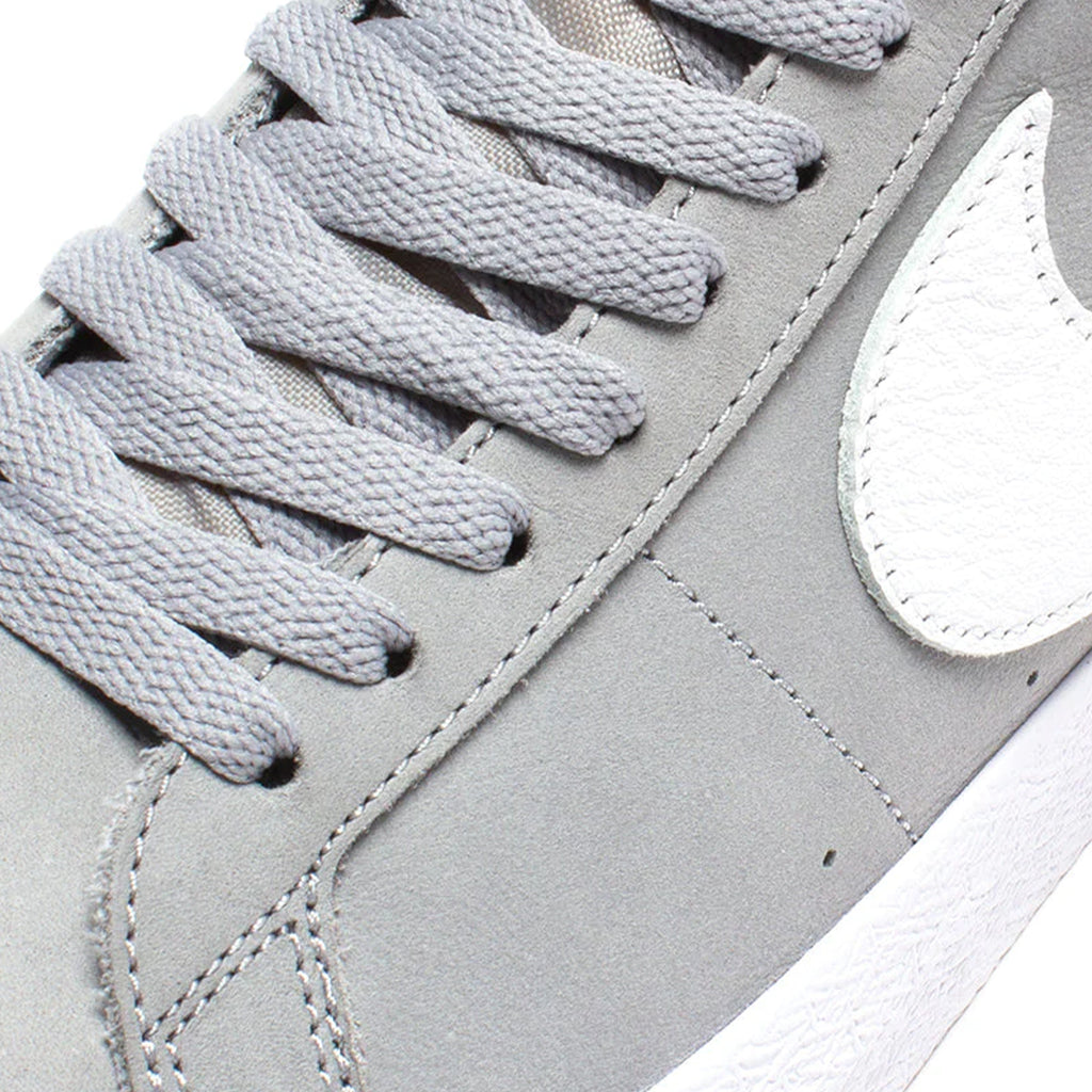 A pair of Nike SB Blazer Mid ISO Wolf Grey/White shoes with a white sole.