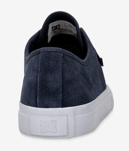 The black view of a navy shoe and a white sole that says DC.