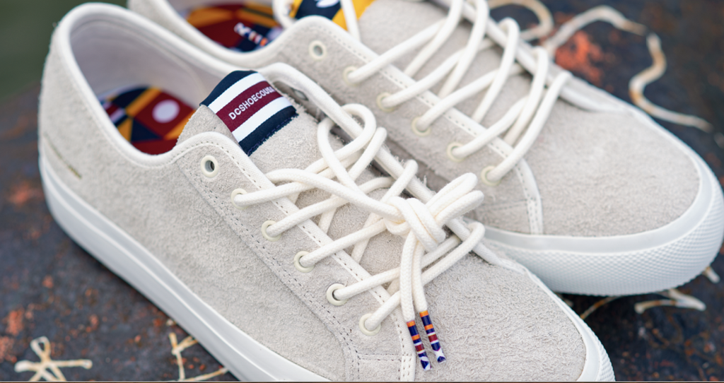 A pair of DC sneakers with colorful nautical flag-inspired laces.