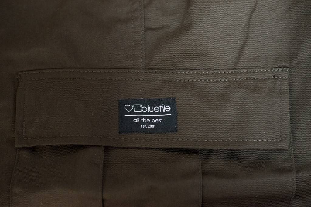 A close up of a comfortable Bluetile Skateboards brown jacket with a label on it.