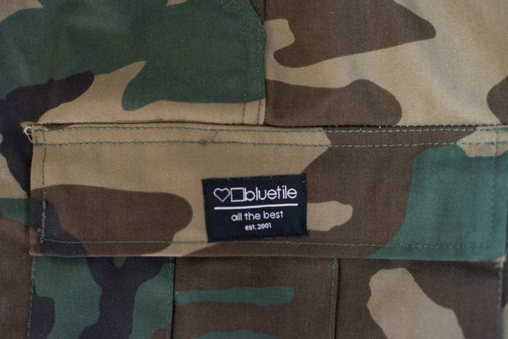 A close up of a durable BLUETILE SURPLUS CARGO PANT CLASSIC CAMO jacket with utility pockets, by Bluetile Skateboards.
